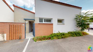 Photo d'une villa du programme neuf Jade à Toulouse montrant la façade extérieure, les accès piétons et les parkings extérieurs.