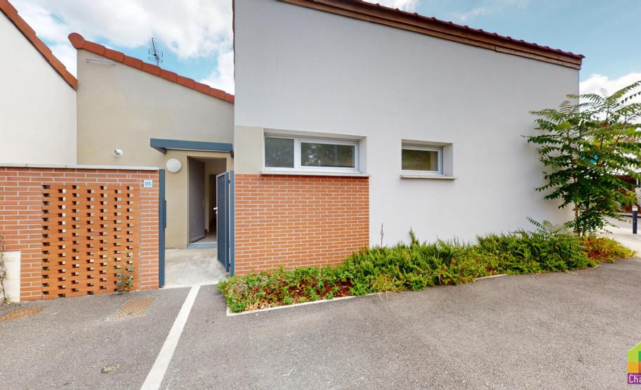 Photo d'une villa du programme neuf Jade à Toulouse montrant la façade extérieure, les accès piétons et les parkings extérieurs.